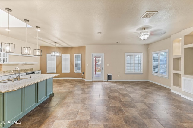 kitchen with ceiling fan, pendant lighting, green cabinets, sink, and built in shelves