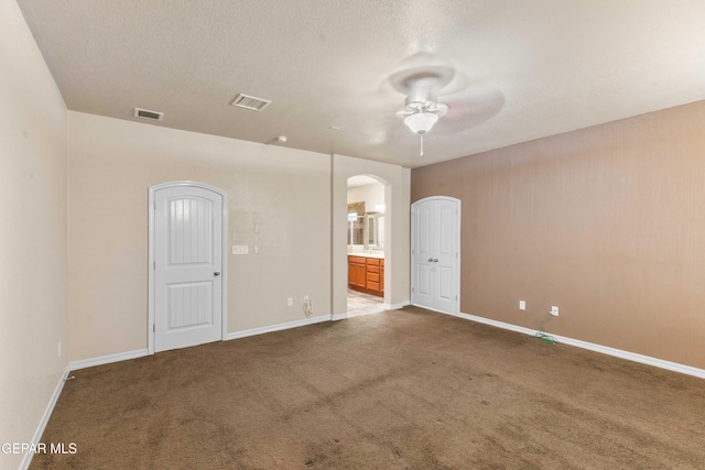 spare room featuring a textured ceiling, ceiling fan, and carpet flooring