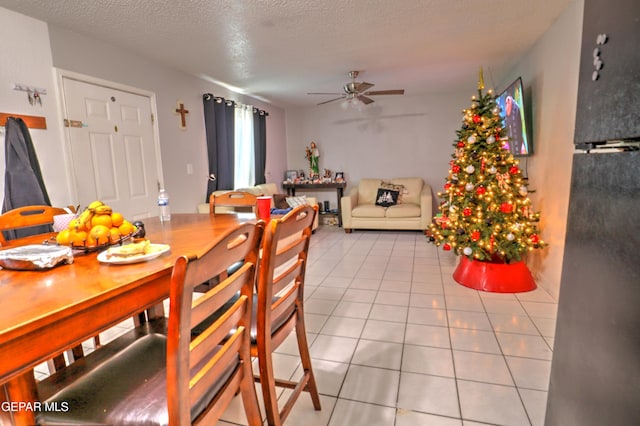 tiled dining room featuring ceiling fan and a textured ceiling