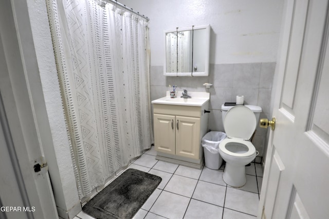 bathroom with toilet, vanity, tile walls, tile patterned floors, and a shower with curtain