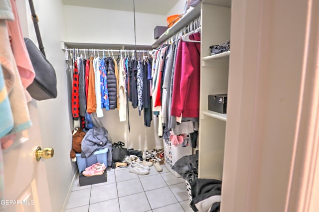 walk in closet with light tile patterned floors