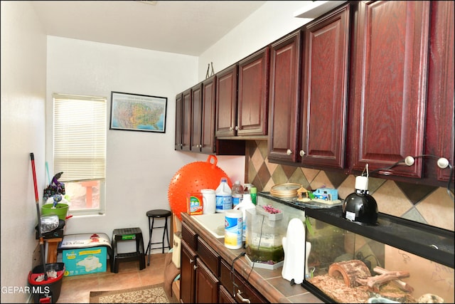 kitchen featuring light tile patterned flooring and backsplash