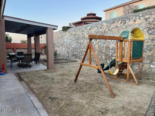 view of playground featuring a patio area