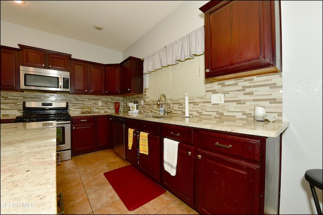 kitchen featuring sink, decorative backsplash, light tile patterned floors, light stone counters, and stainless steel appliances