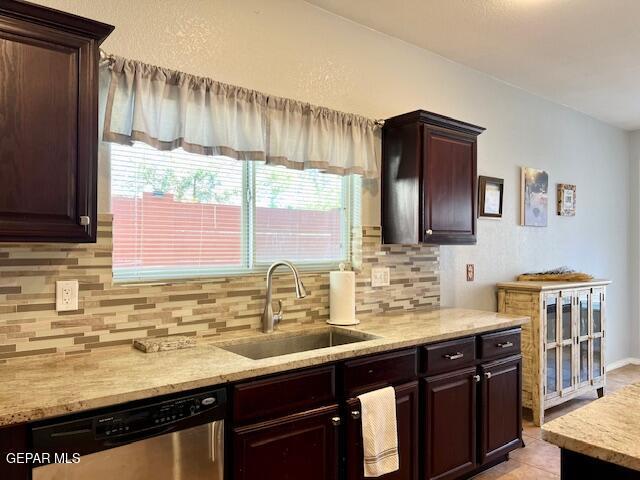 kitchen with tasteful backsplash, sink, stainless steel dishwasher, and dark brown cabinetry