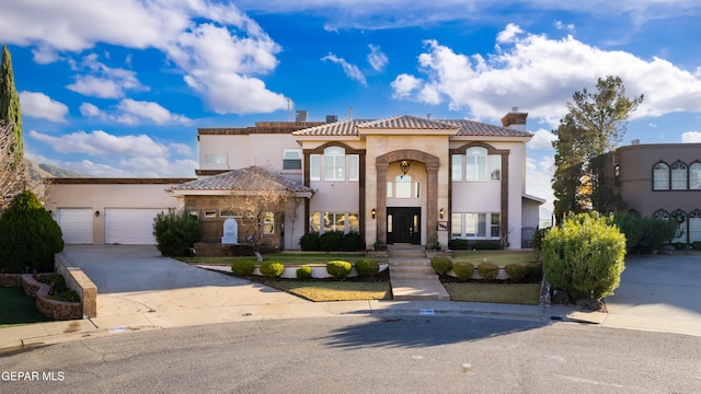 mediterranean / spanish-style home with a garage