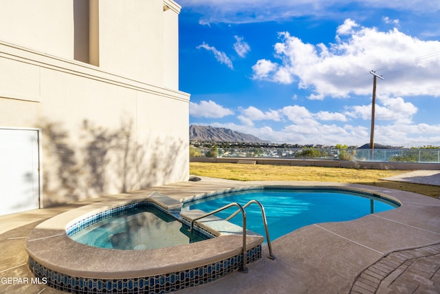 view of pool with a mountain view and an in ground hot tub