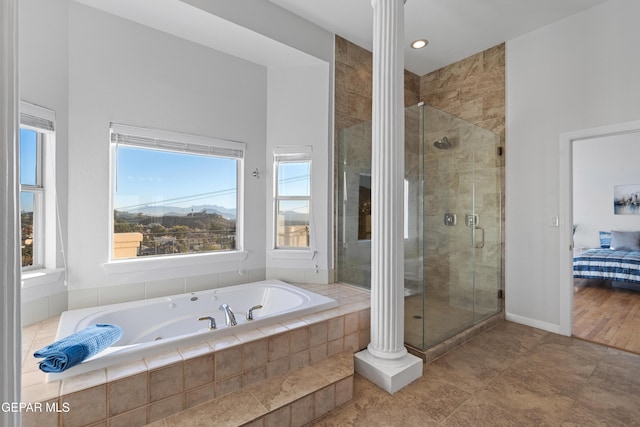 bathroom with plenty of natural light, ornate columns, and independent shower and bath