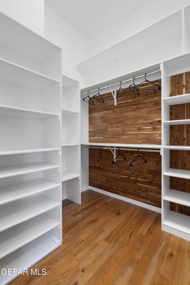 spacious closet with hardwood / wood-style floors