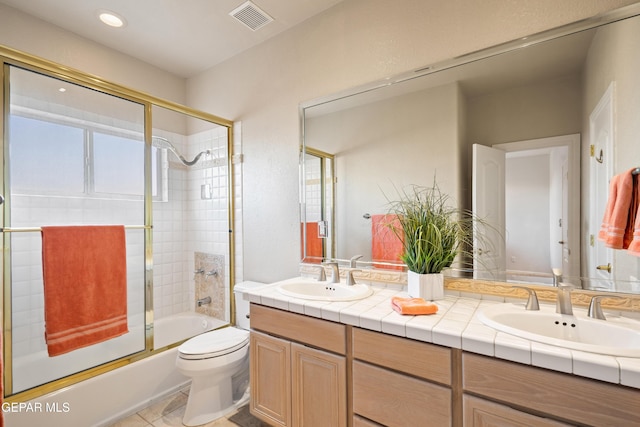 full bathroom with toilet, tile patterned flooring, vanity, and shower / bath combination with glass door