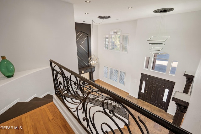 stairs with a wealth of natural light and hardwood / wood-style floors