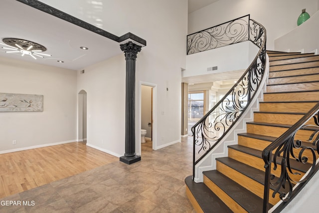 foyer featuring ornate columns and a towering ceiling