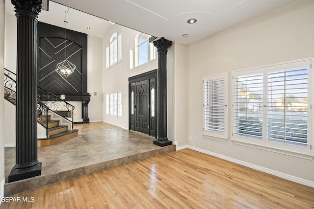 foyer entrance featuring wood-type flooring and ornate columns