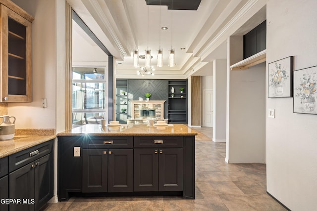 kitchen featuring built in shelves, pendant lighting, kitchen peninsula, and light stone countertops