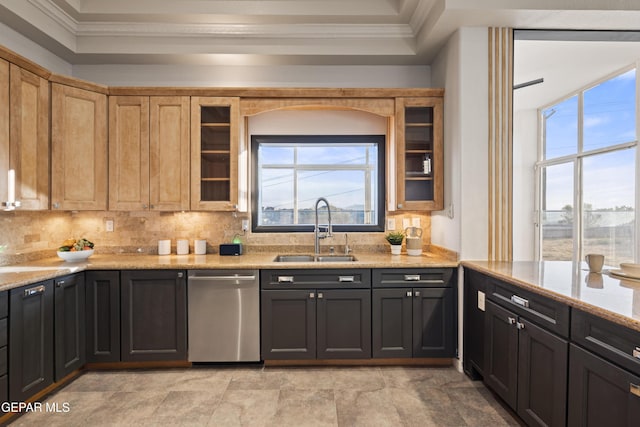 kitchen with a wealth of natural light, dishwasher, light stone countertops, ornamental molding, and sink