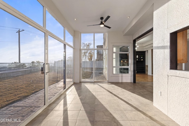 unfurnished sunroom featuring ceiling fan