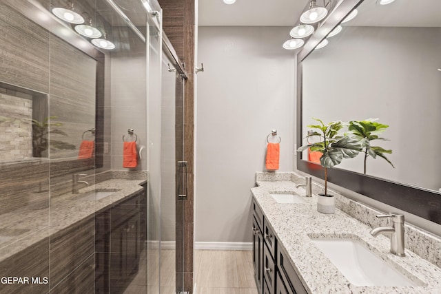 bathroom featuring a shower with shower door and vanity