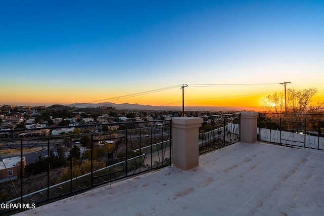 balcony at dusk featuring a mountain view