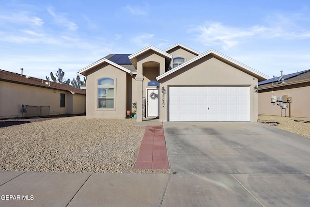 single story home with a garage and solar panels