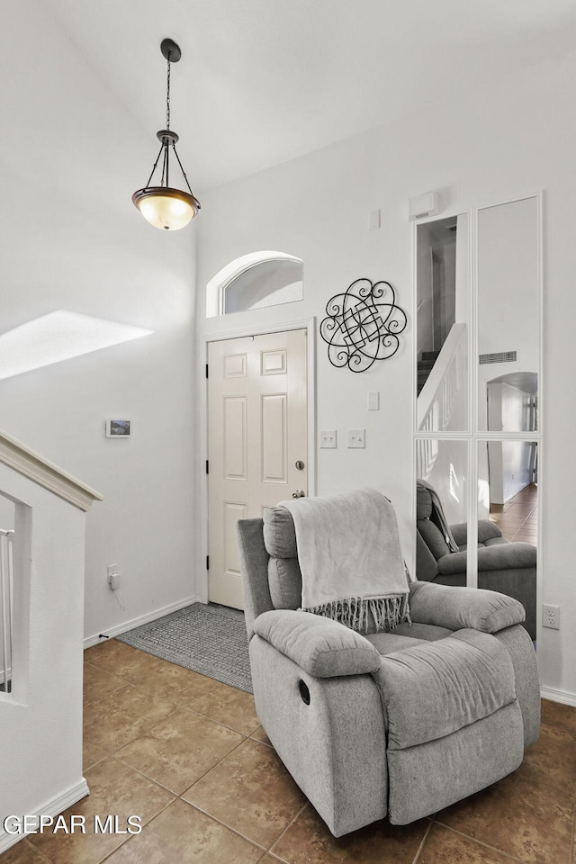 living room featuring tile patterned flooring and a high ceiling