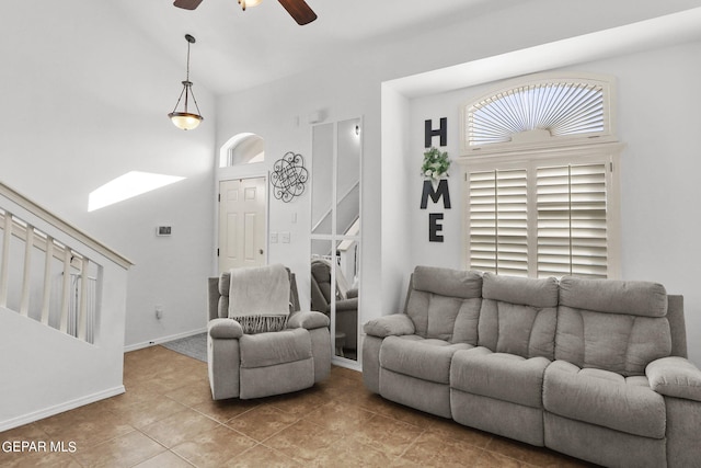 living room with ceiling fan, light tile patterned floors, and a high ceiling