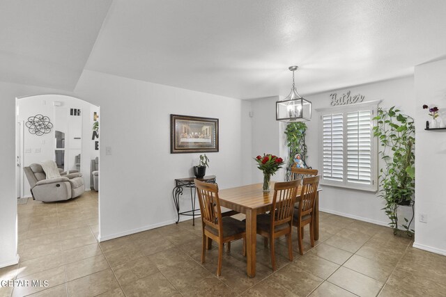 tiled dining area featuring an inviting chandelier