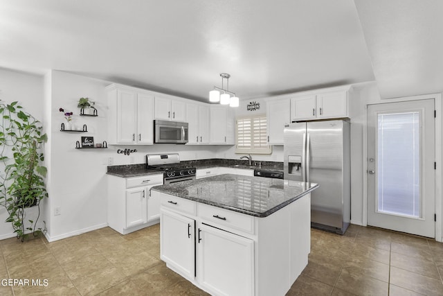 kitchen with white cabinets, hanging light fixtures, appliances with stainless steel finishes, and a kitchen island