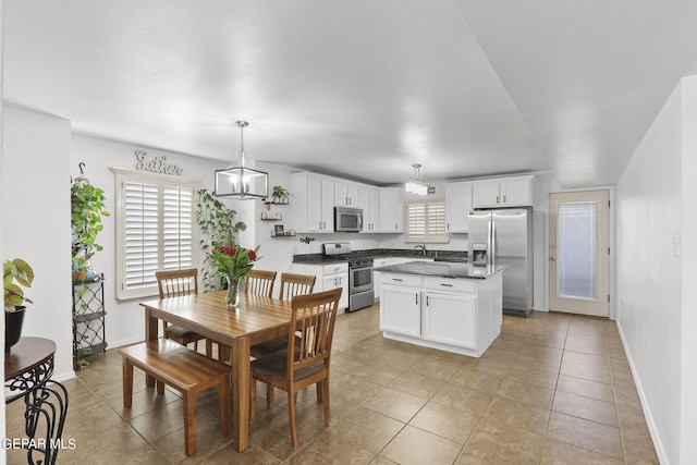 tiled dining space featuring sink and a chandelier