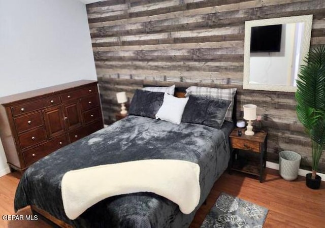 bedroom featuring wood walls and light wood-type flooring