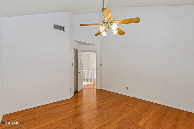 spare room with lofted ceiling, ceiling fan, a textured ceiling, and hardwood / wood-style floors