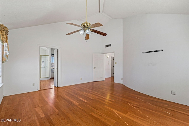 unfurnished bedroom with ceiling fan, ensuite bath, high vaulted ceiling, and hardwood / wood-style floors