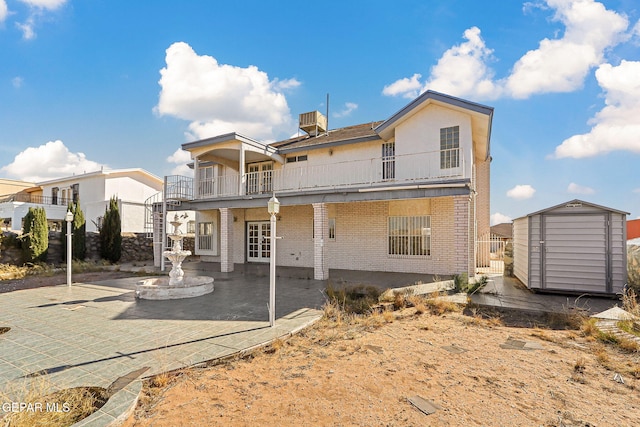 rear view of house with central AC, a storage unit, a balcony, and a patio