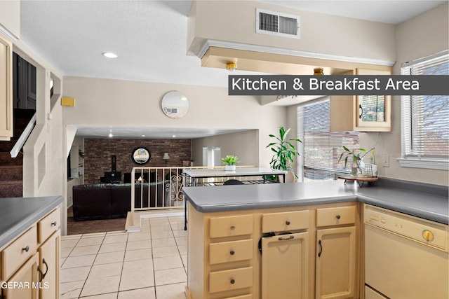 kitchen with a wood stove, light tile patterned floors, dishwasher, and kitchen peninsula