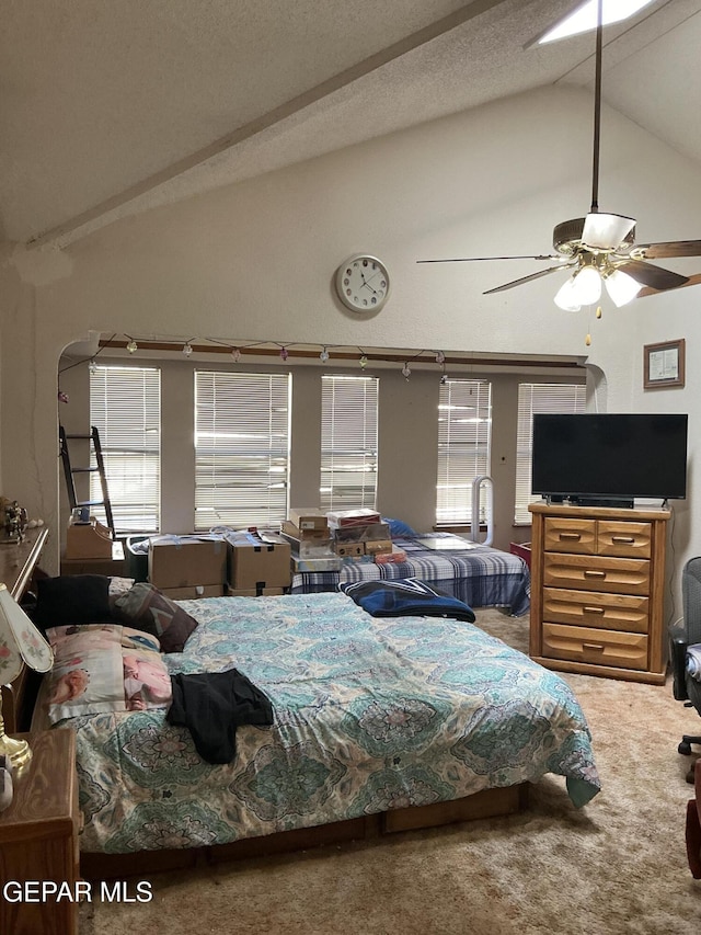 carpeted bedroom with ceiling fan, vaulted ceiling, and a textured ceiling