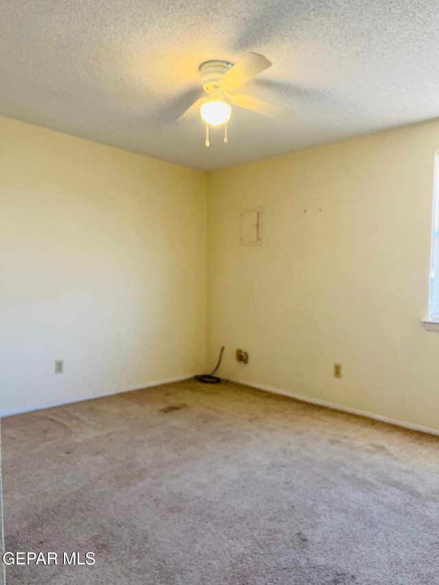 carpeted empty room with ceiling fan and a textured ceiling