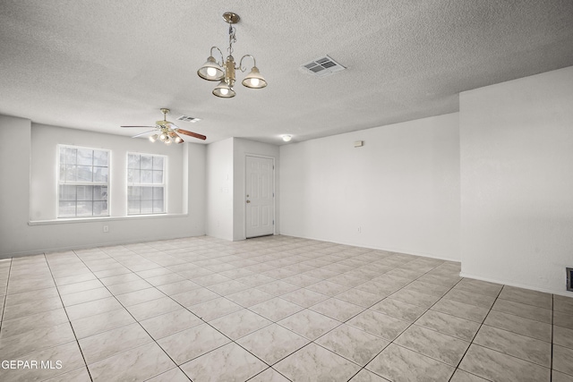 tiled empty room with a textured ceiling and ceiling fan with notable chandelier