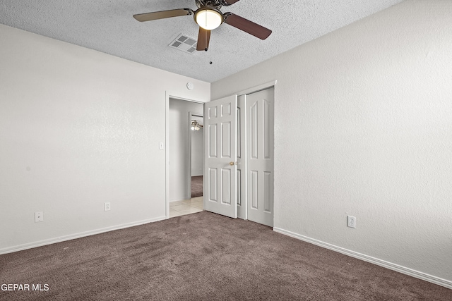 unfurnished bedroom featuring a textured ceiling, ceiling fan, a closet, and light colored carpet