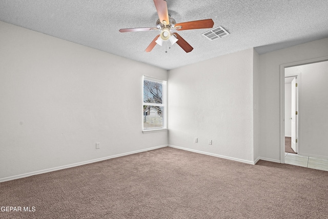 carpeted spare room featuring a textured ceiling and ceiling fan