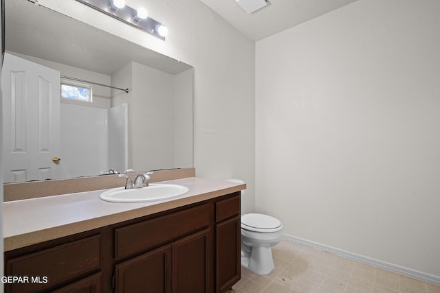 bathroom with toilet, walk in shower, and vanity