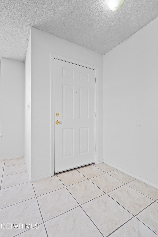 tiled entryway featuring a textured ceiling