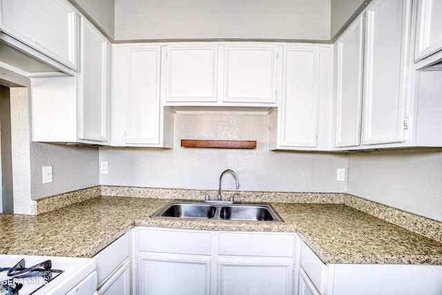 kitchen featuring white cabinets and sink