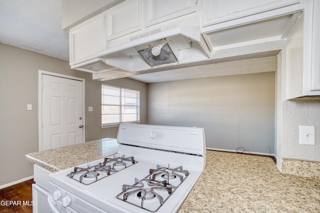 kitchen featuring a textured ceiling, dark wood-type flooring, white cabinetry, and white gas range oven