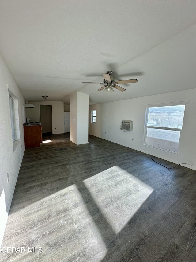 unfurnished living room with ceiling fan and an AC wall unit