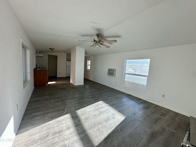 unfurnished living room featuring ceiling fan, lofted ceiling, dark wood-type flooring, and a wall mounted air conditioner