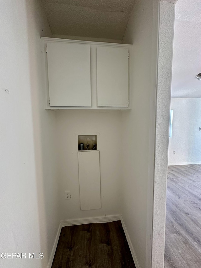 washroom featuring cabinets, wood-type flooring, a textured ceiling, and hookup for a washing machine