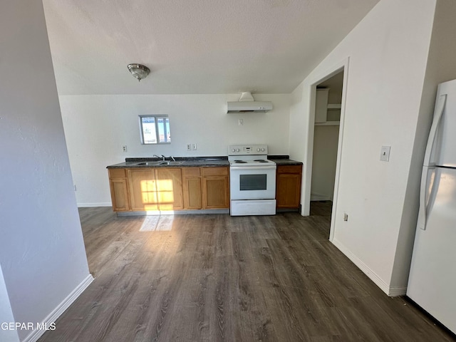 kitchen with dark wood-type flooring, sink, white appliances, and a textured ceiling