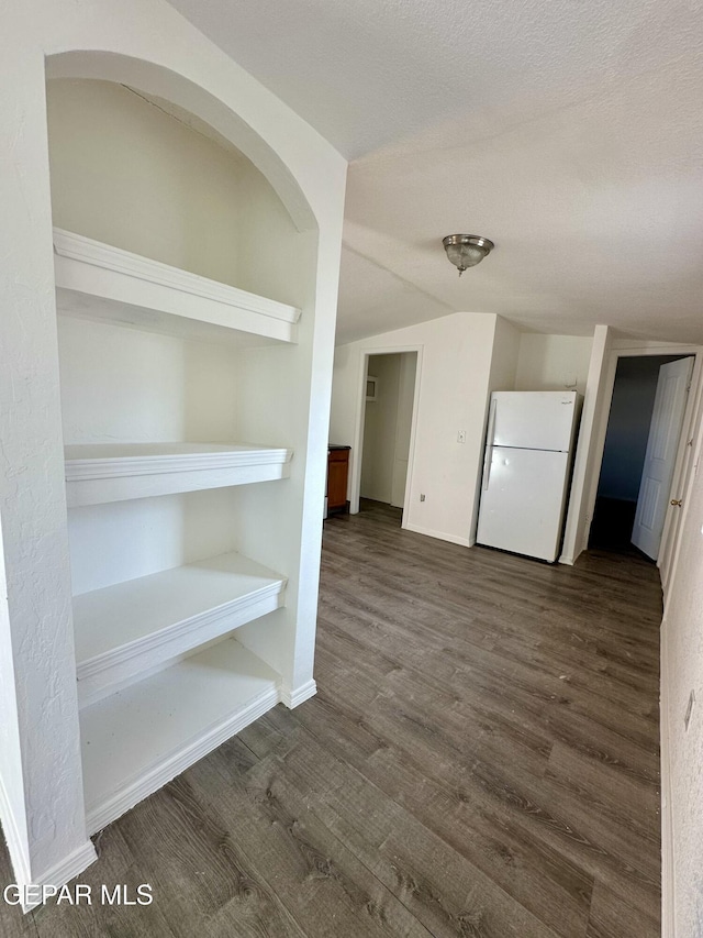 interior space with lofted ceiling, dark hardwood / wood-style flooring, and a textured ceiling