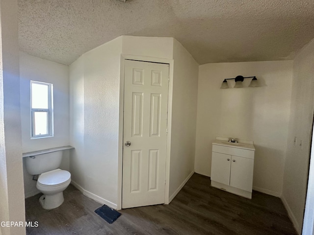 bathroom featuring a textured ceiling, toilet, and hardwood / wood-style floors