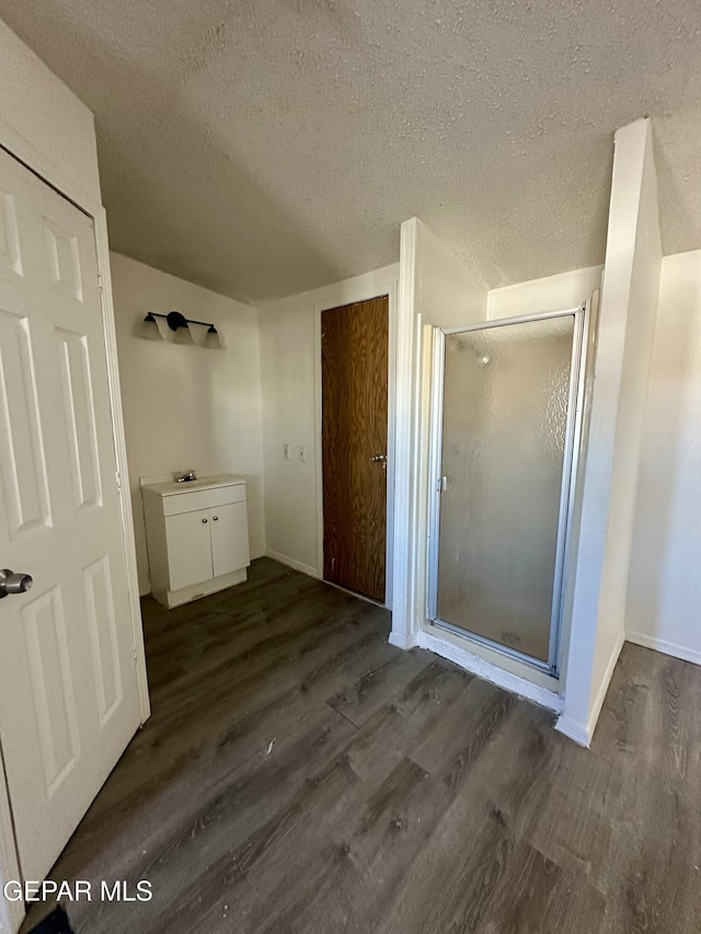 bathroom featuring sink, wood-type flooring, walk in shower, and a textured ceiling