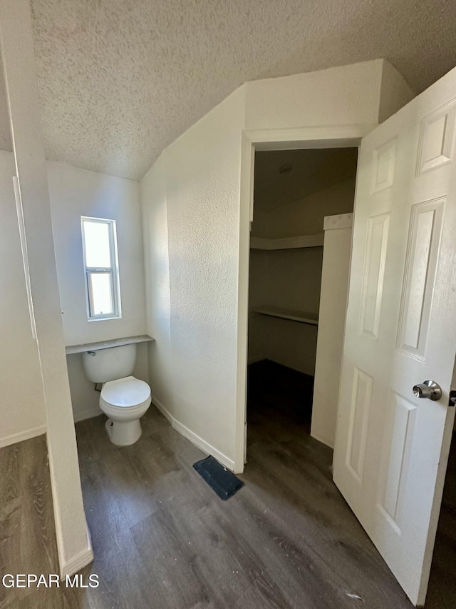 bathroom with a textured ceiling, toilet, and hardwood / wood-style flooring